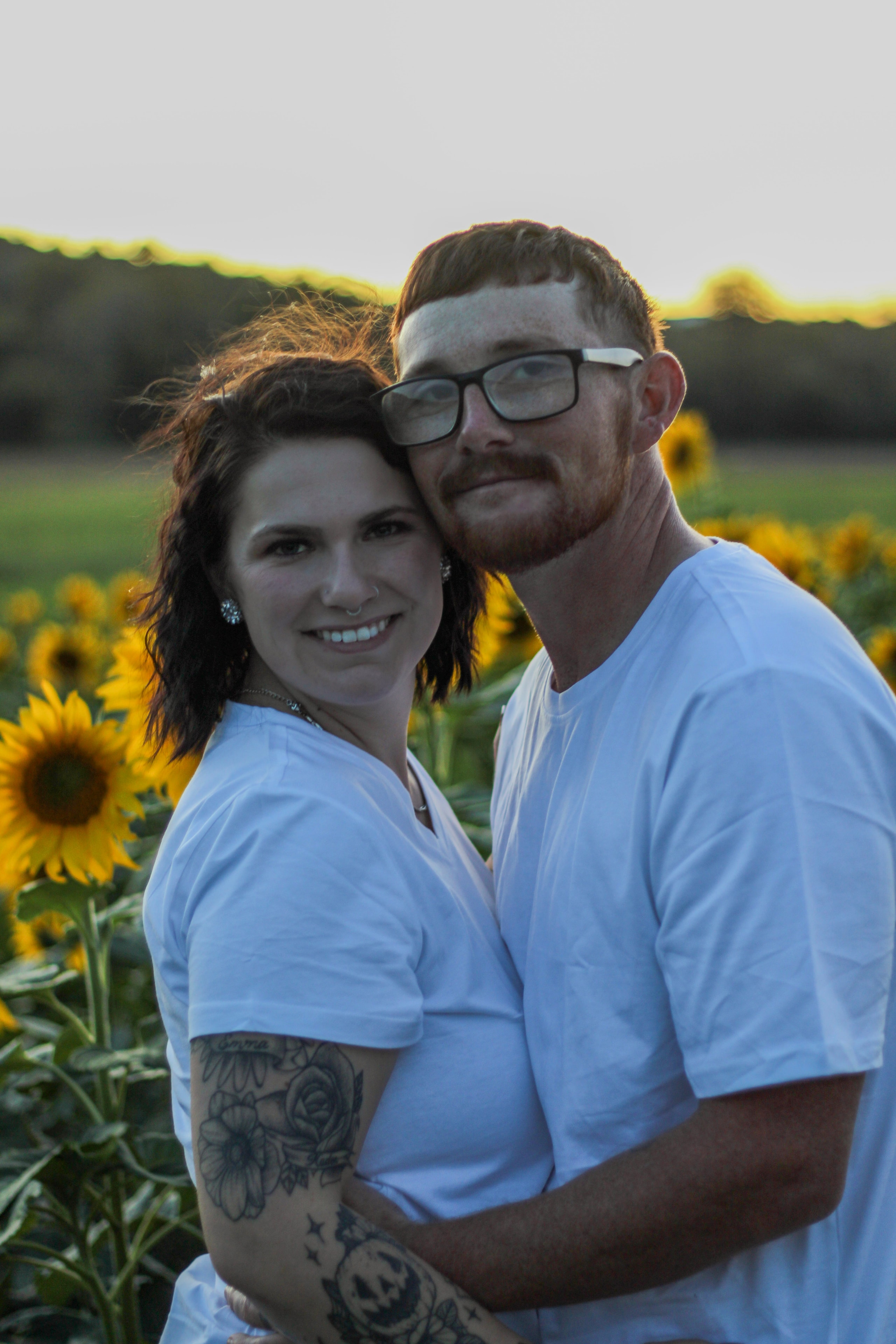 Couple posing together in a sunflower field
