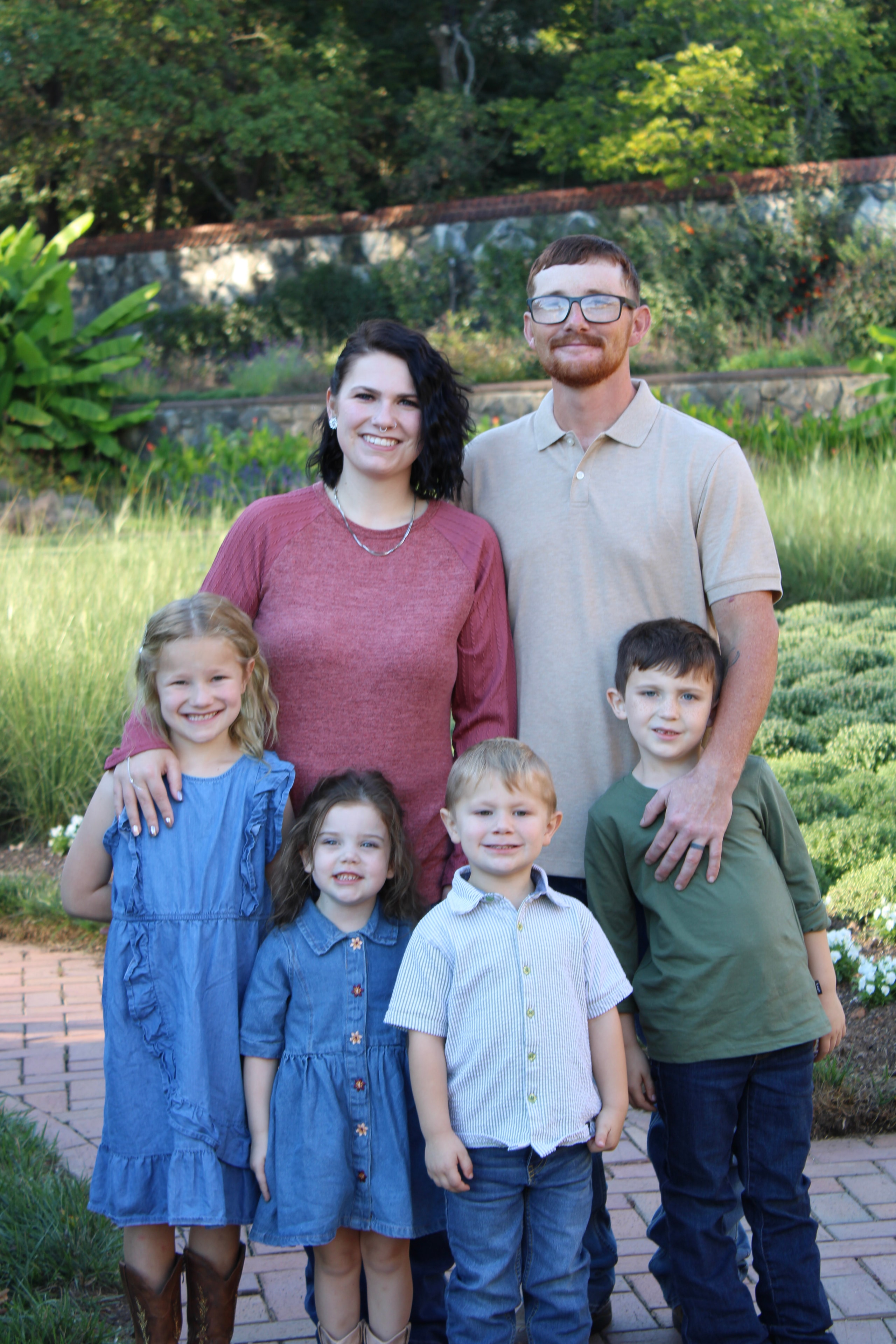 Family of five posing together in the garden