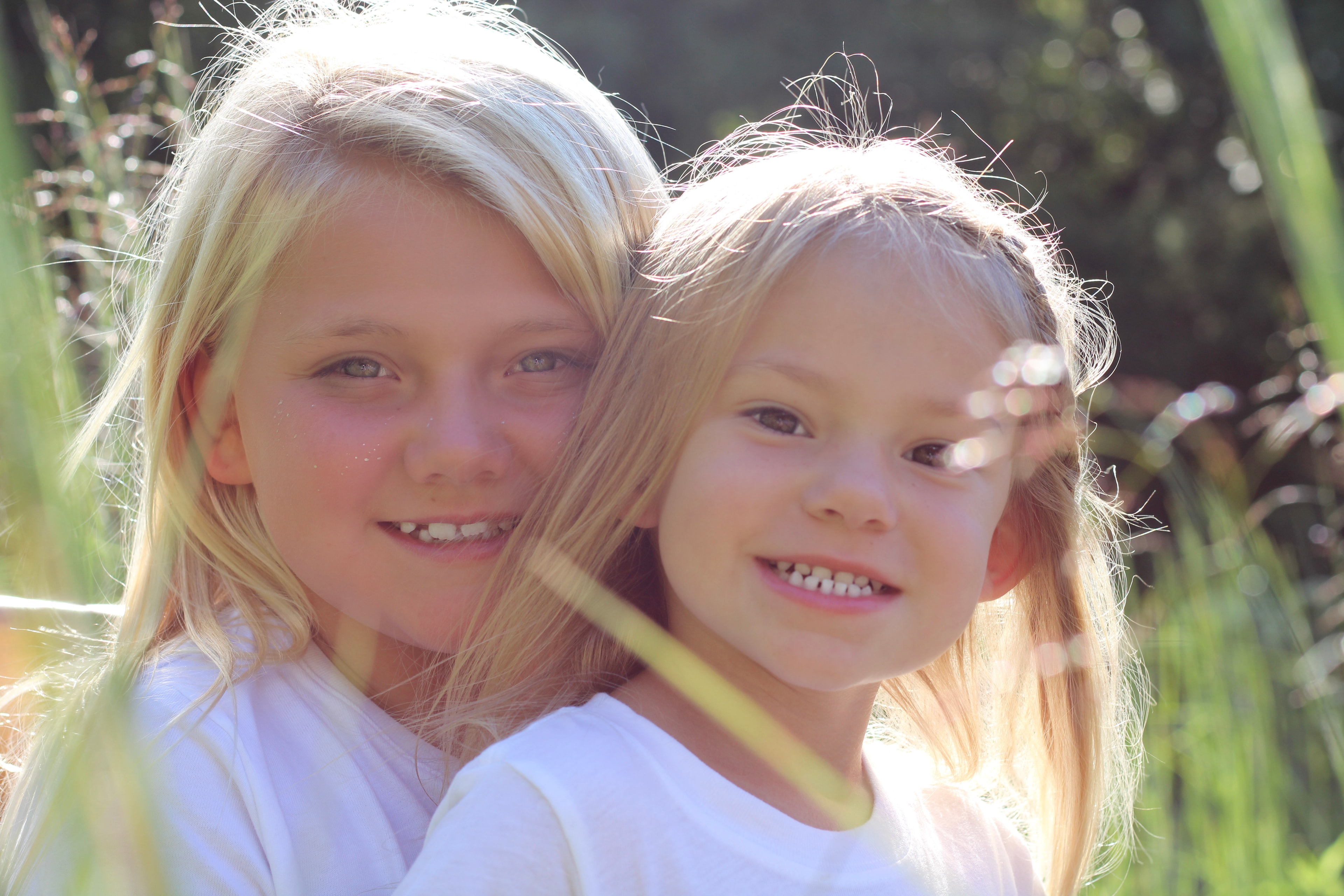 Two young girls smiling together outdoors