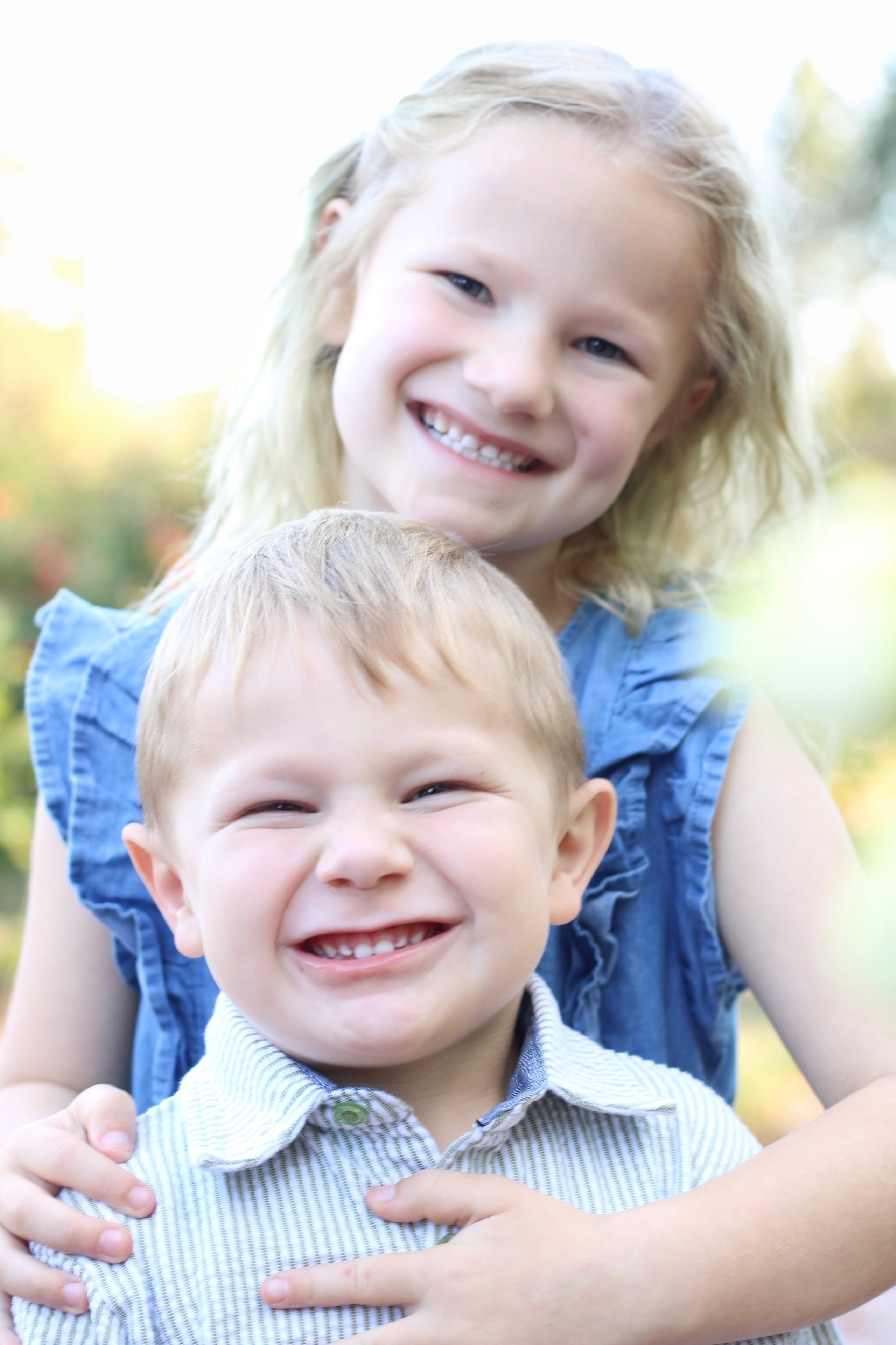 Two young children smiling together outdoors