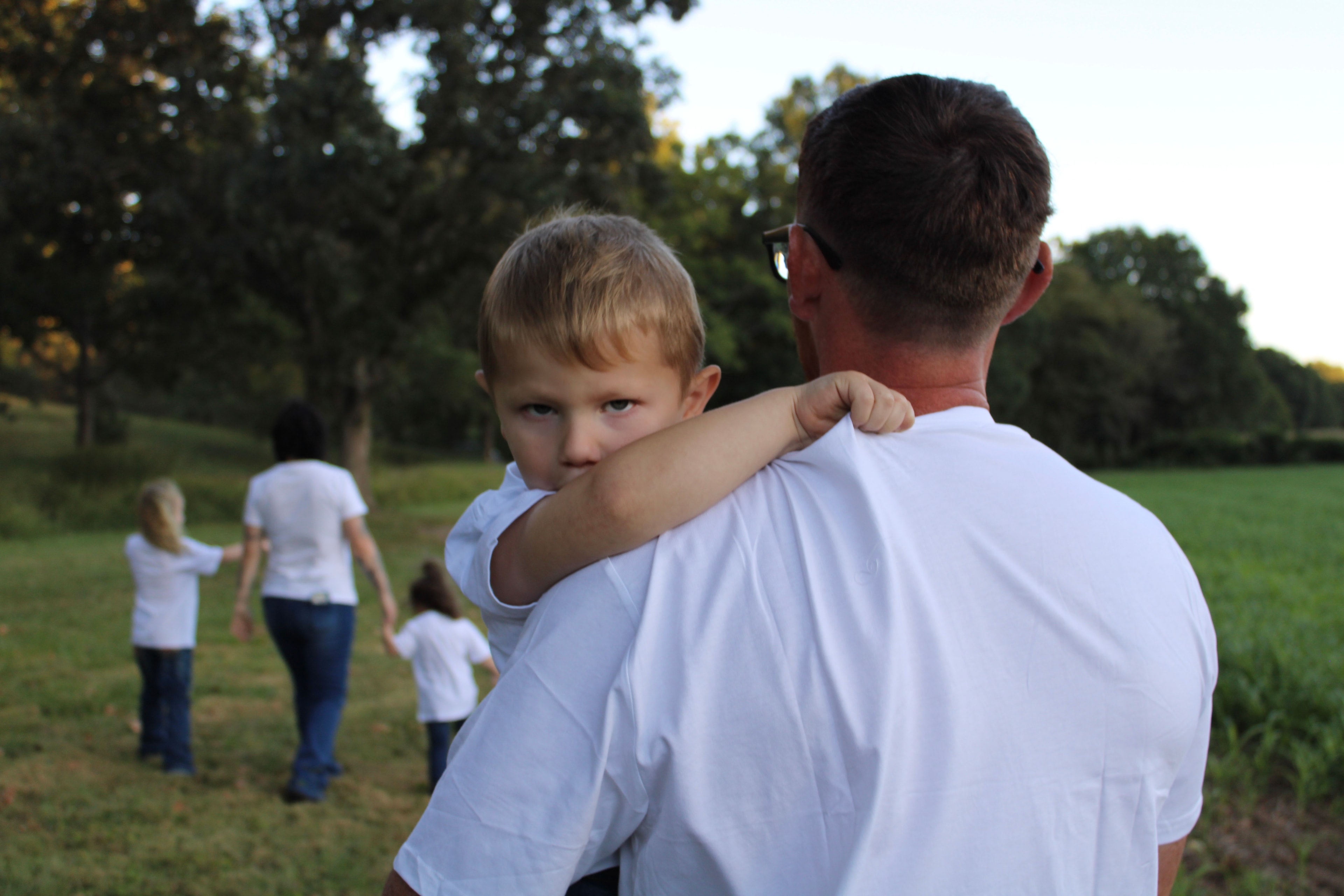 Father holding toddler in the park
